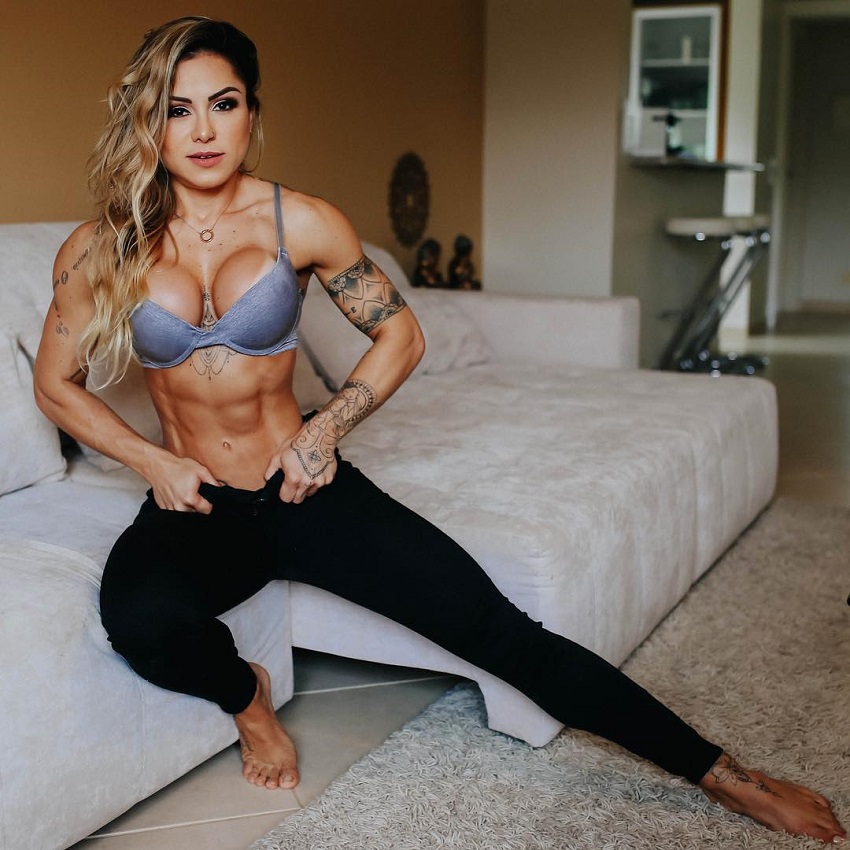 Carol Franca flexing her muscles in her room, looking fit and ripped